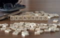 Scrabble pieces spelling "EXHAUSTED"