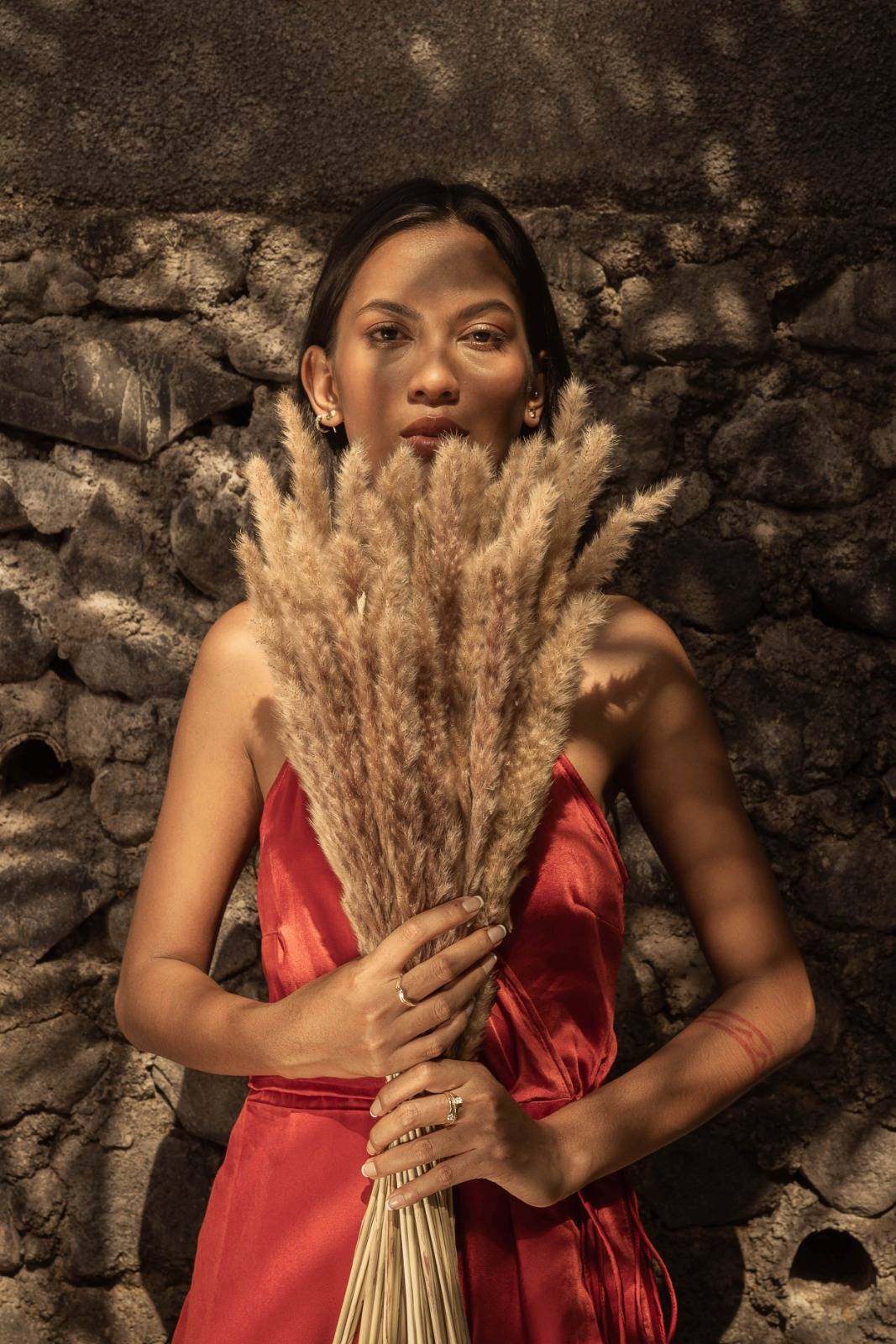 Woman wearing red dress and Sceona sustainable jewellery pieces