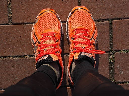 Orange running shoes on road