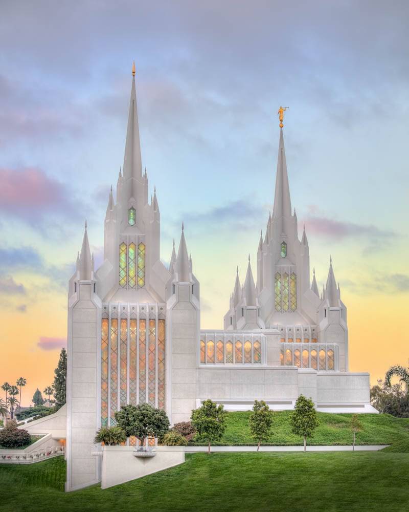 Vertical photo of the San Diego Temple from the side, focusing on the colorful windows and tall steeples.