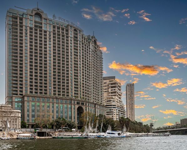 CAIRO, EGYPT - APRIL 26, 2022 View from the Nile river with Four Seasons Hotel Cairo at Nile Plaza, Water Taxi Garden City Station in front and others important skyscraper in the vicinity.