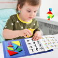 Little boy playing with Magnetic Tangram puzzles and swiping trough a book with different shapes and models.