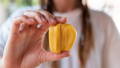 woman holding a raw jackfruit bud as an alternative to meat for vegans