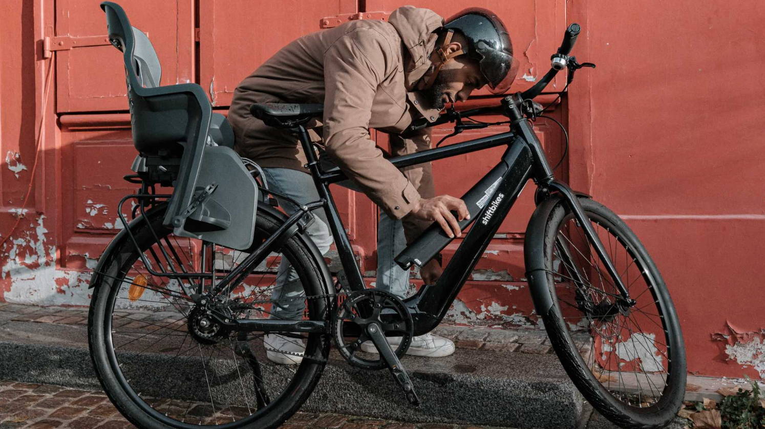 Un homme applique les conseils ShiftBikes pour prendre soin de la batterie de son VAE