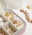 Silver and Gold Jewelry Appraisals Guide A small pink velvet jewelry box containing gold rings and pearl jewelry next to a gold bracelet
