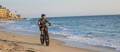 Man riding electric bike on beach sand