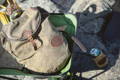 summit pack sitting in a lawn chair on a rocky beach with a beer on the ground