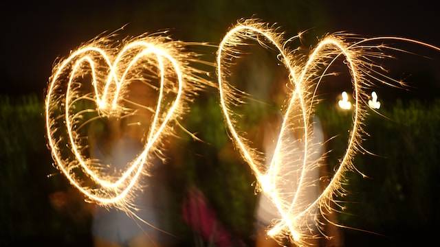 due cuori disegnati per aria con le scintille. Fotografati con la tecnica del light painting e lunga esposizione