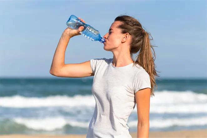 Une femme en train de boire de l'eau.