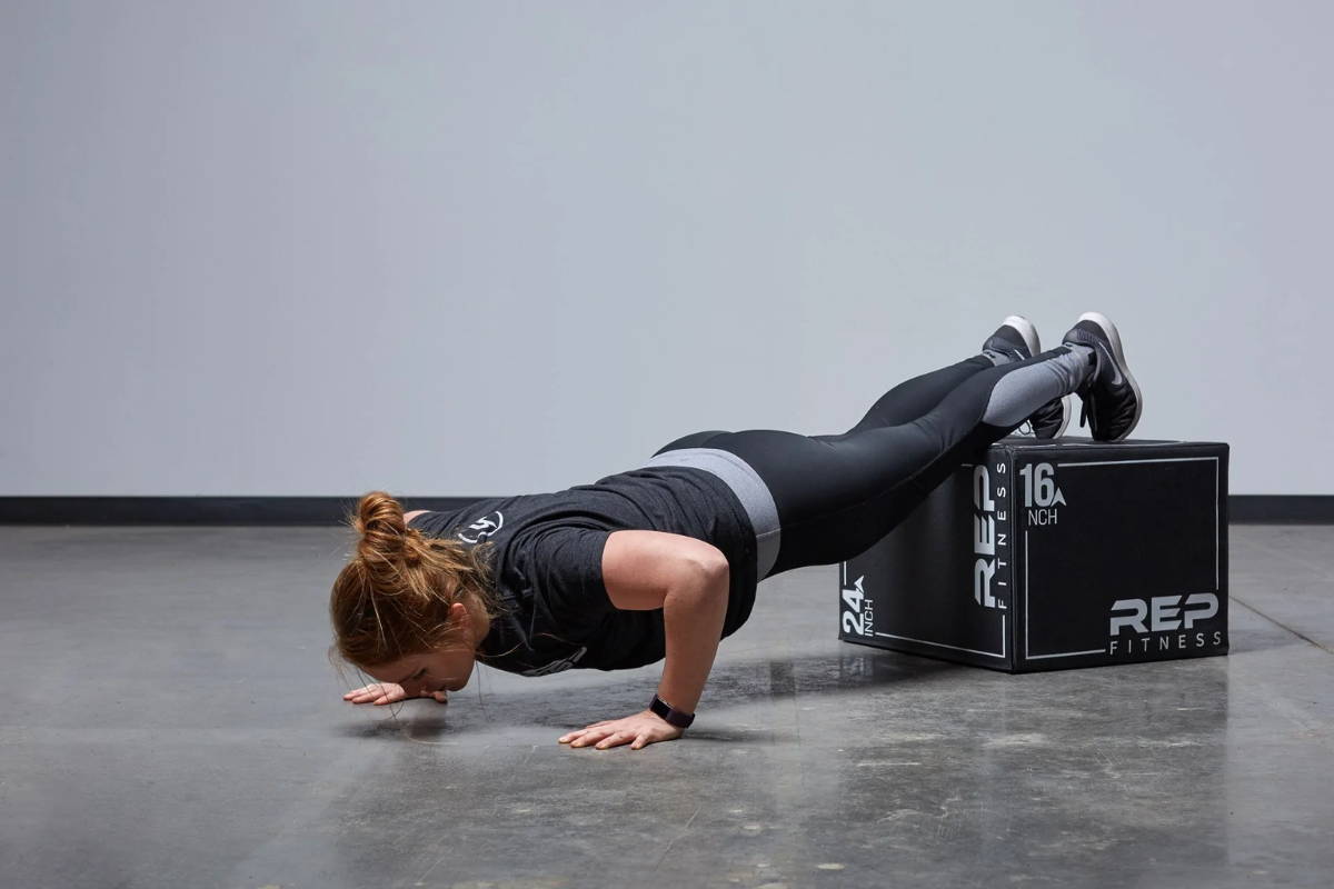 athlete exercising with plyo box elevated push-aps