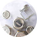 An overhead view of empty magnetic jars by Gneiss Spice laying on a table, with one clearly labaled 'Rosemary'