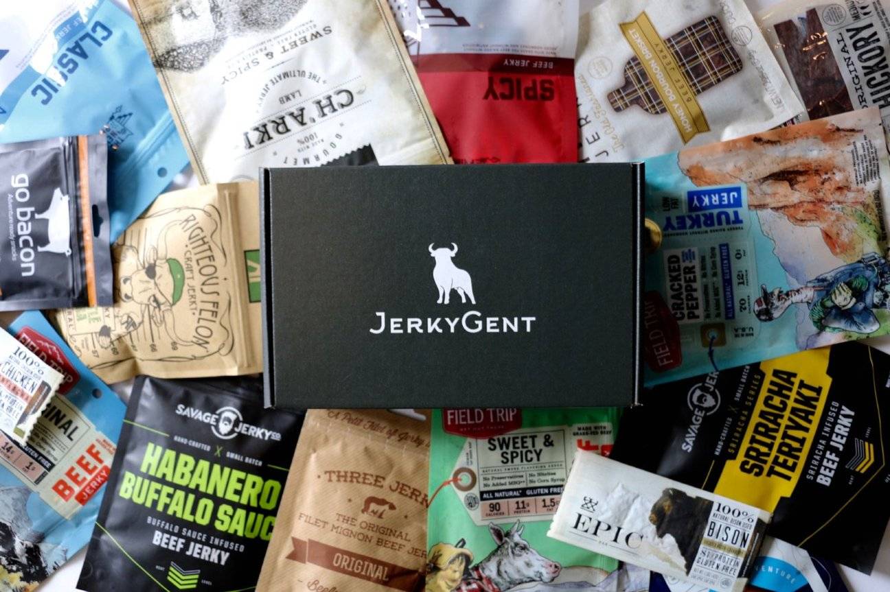 Beef jerky subscription box sitting on top of tons of craft beef jerky.