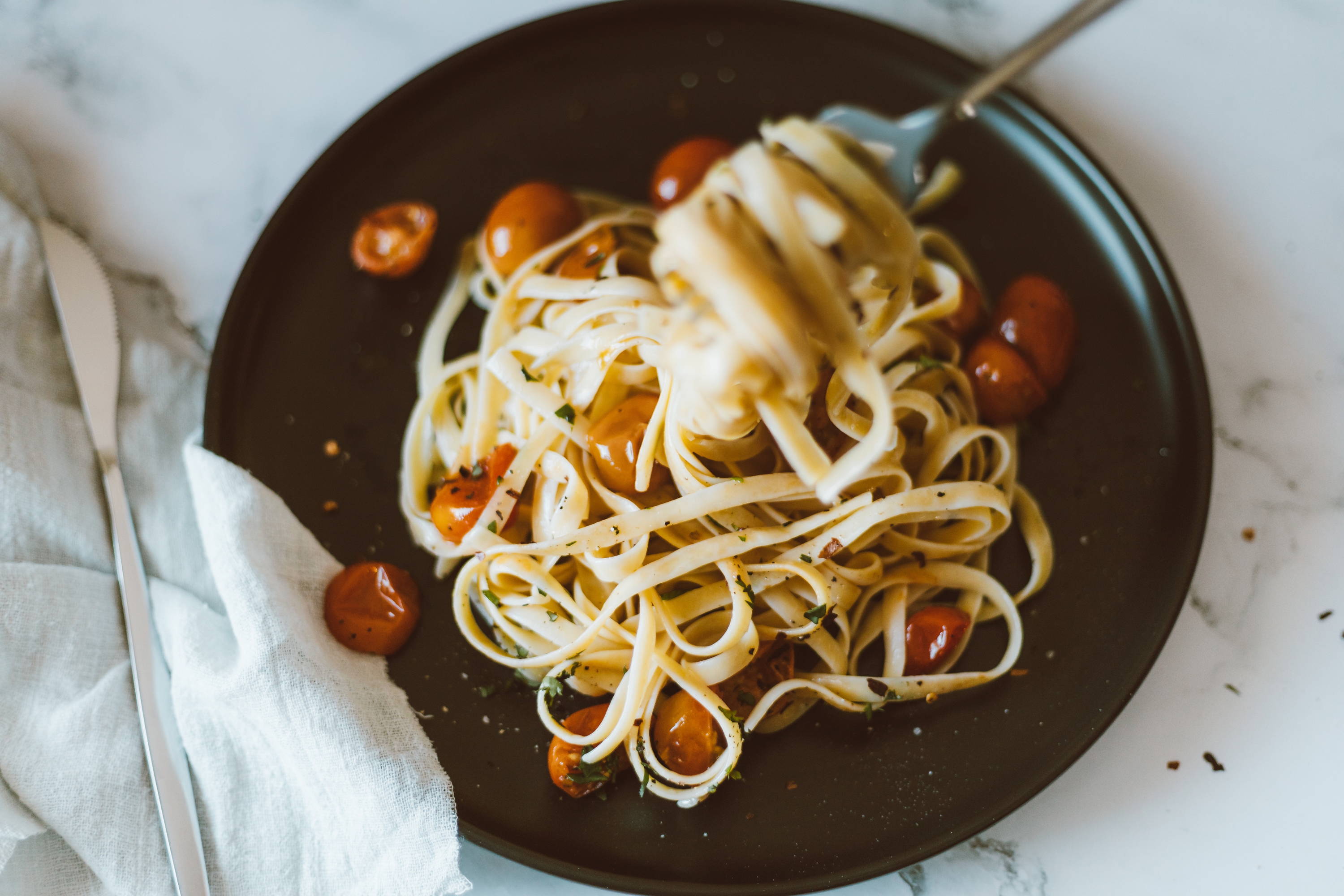 Linguine pasta with roasted sweet cherry tomatoes drizzled in olive oil to pair with Feisty Kiss of Wine Nebbiolo. 