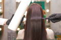 Brown haired woman getting keratin treatment at salon