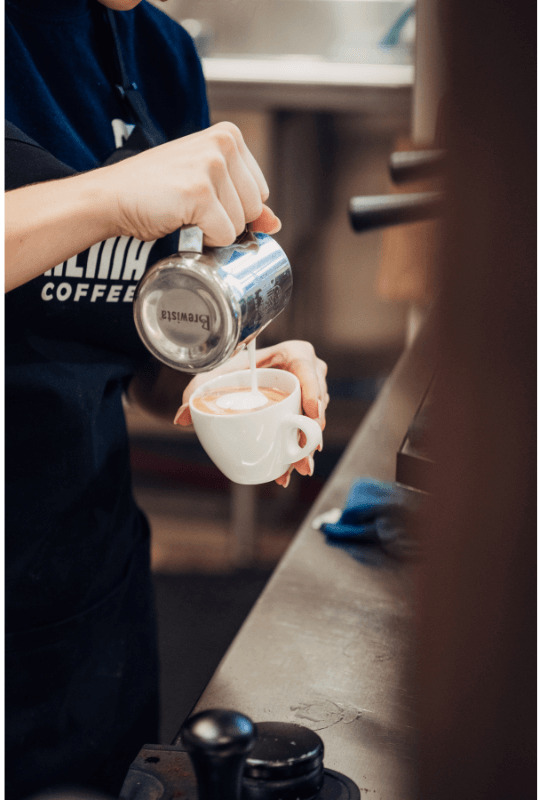 Barista pouring a Cafe Au Lait. 