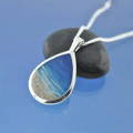 ashes necklace in a teardrop shape in the style of an idyllic beach. perfect memorial pendant