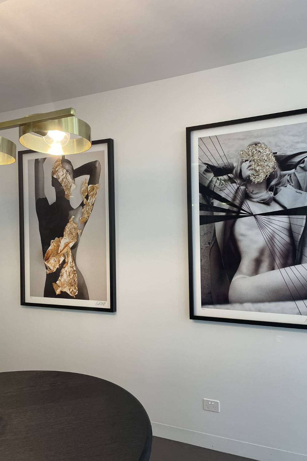 'Champagne On Ice' by Dina Broadhurst - A black and white photographic print of a figure embellished with gold glitter, framed in black and styled in a kitchen/dining space.