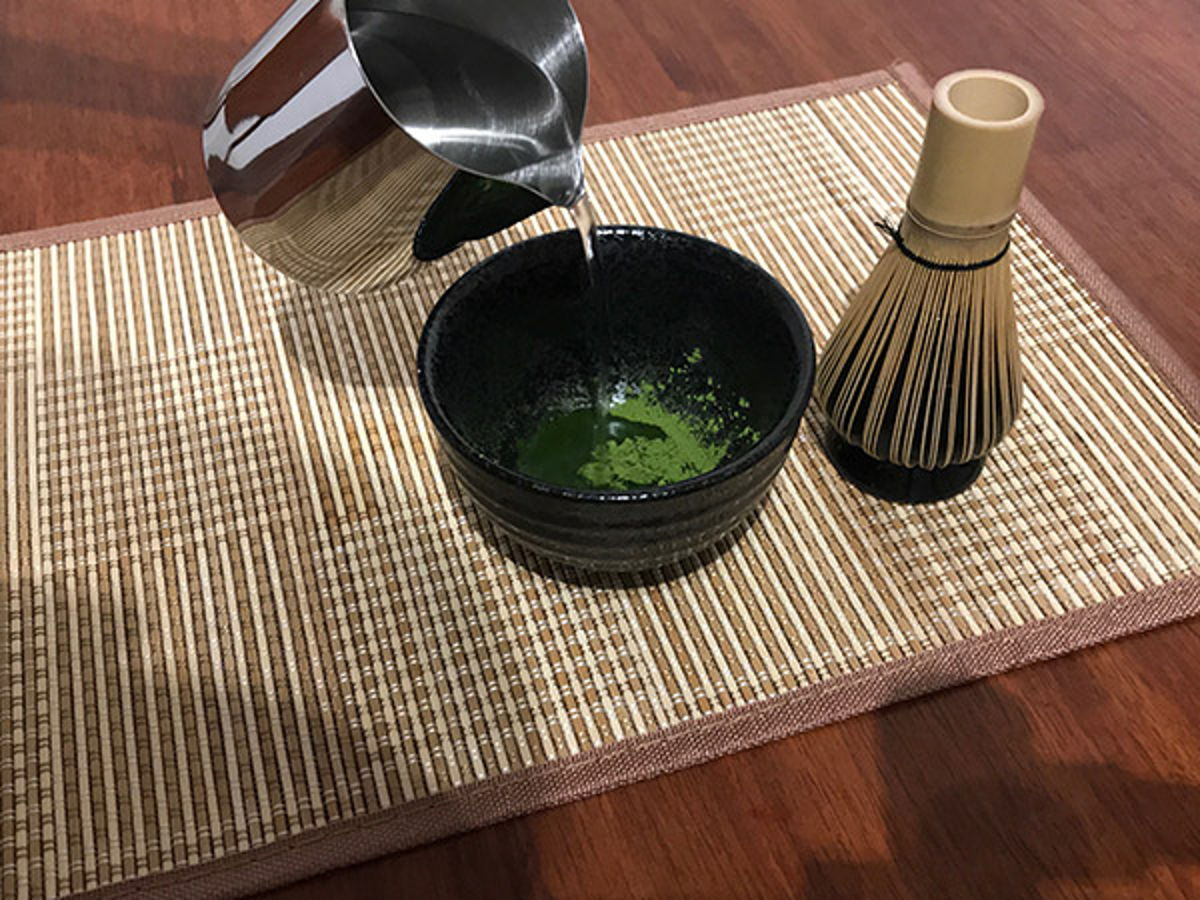 Add warm water to matcha bowl