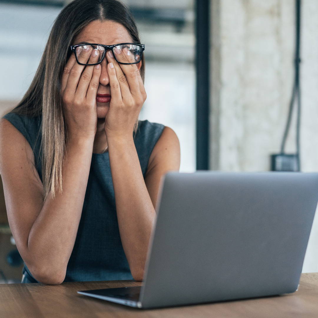 mujer cansada frente a su portatil
