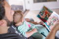 Man reading a book to a baby.