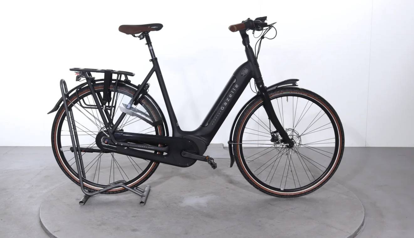 Gazelle Paris C7 elektrische stadsfiets met lage instap, afgebeeld in zijaanzicht op neutrale achtergrond, met Bosch middenmotor, gesloten kettingkast, verende voorvork en zadelpen, MIK-bagagedrager en spatborden – gericht op comfortabel dagelijks gebruik en woon-werkverkeer.