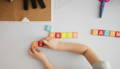 A child playing with wooden numbers on the desk