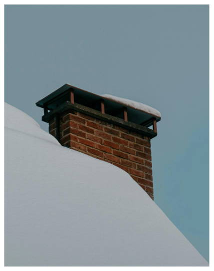 Brick chimney with snow buildup highlighting moisture exposure and potential water intrusion issues