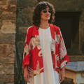 A woman wearing a One Hundred Stars Kimono with a bold red stork print