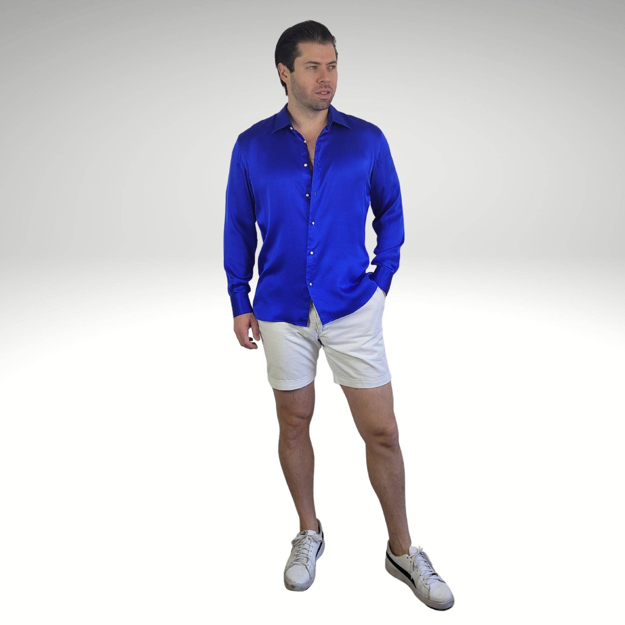photo of a model wearing a long sleeve blue silk shirt with white shorts and white athletic shoes