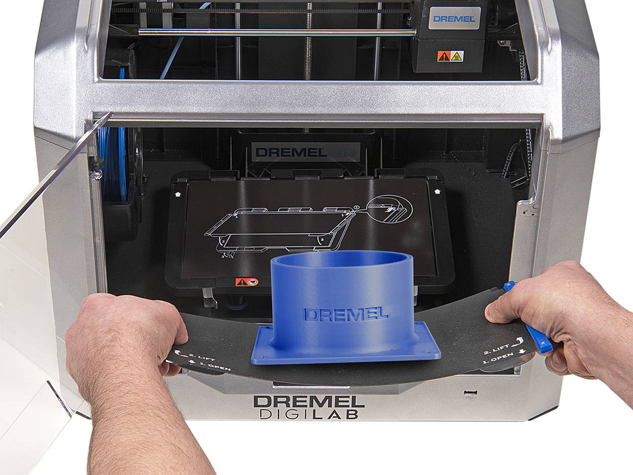 Frontal view of 3D40-FLX 3D printer showing hands removing and flexing the build plate to remove a printed bracket