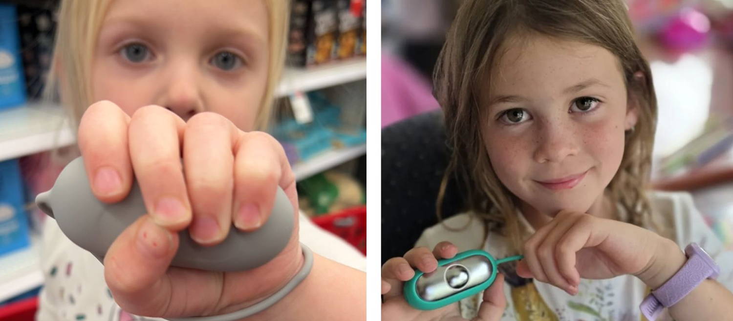 Two young girls holding the CalmCarry handheld calming device