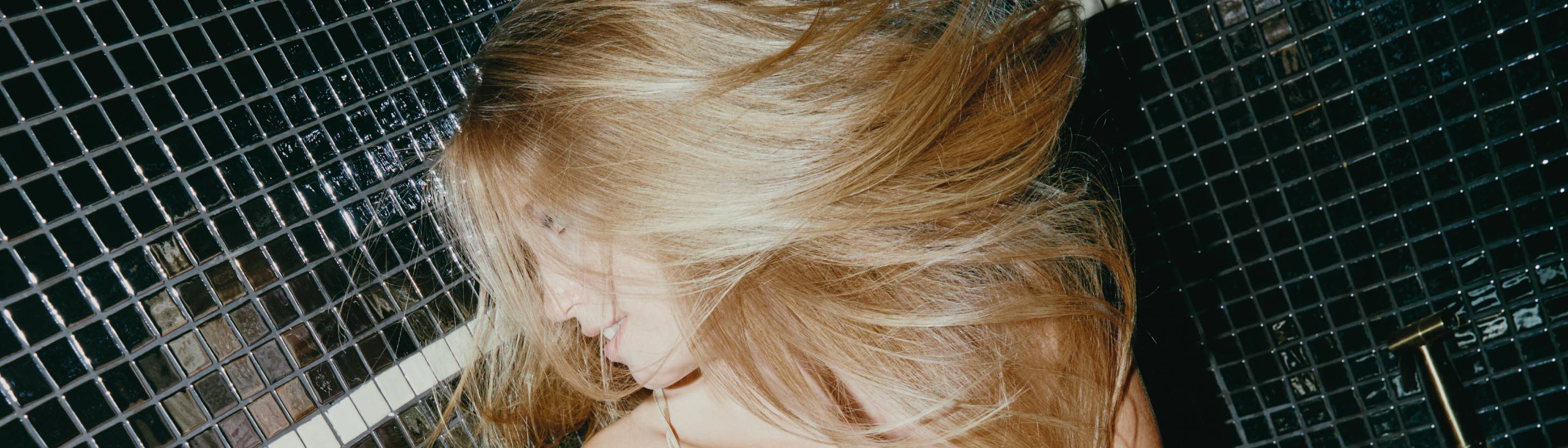 woman whipping her sleek blonde hair