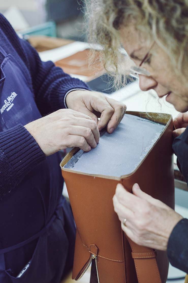 2 women creating an opus mind brown handbag in their factory in Florence 