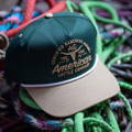green American cattle company hat sitting on rope