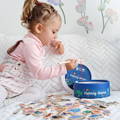 Little girl holding a rod and pulling magnetic fish from a bucket. 