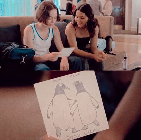 Image of Izzie and Casey sitting together on a couch looking together at a image of the two penguins with the words Good Luck written on it.