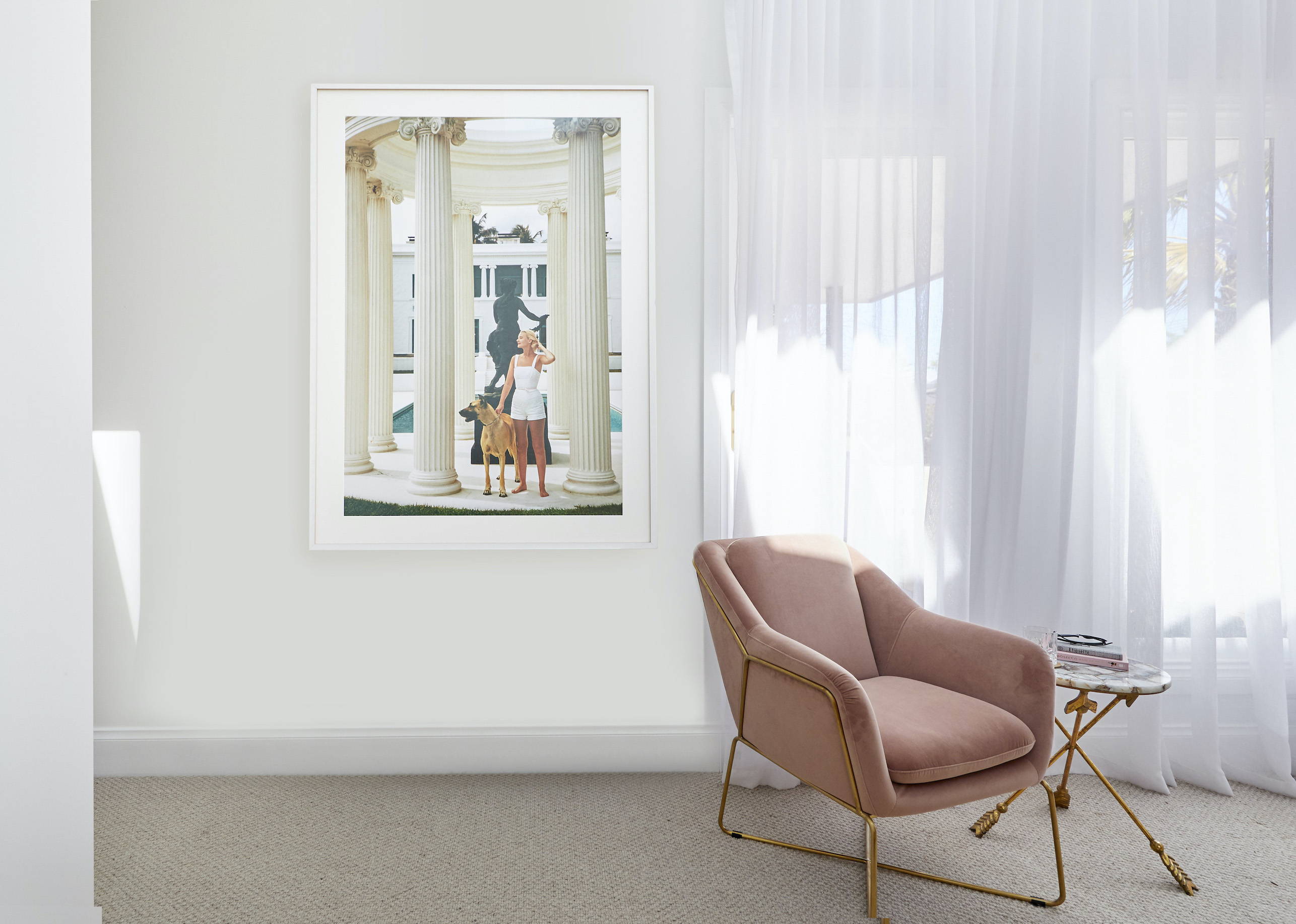 A TV-Mirror hanging on the wall of a coastal, elegant bedroom setting 