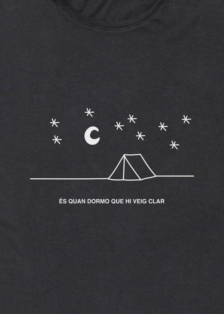 Camiseta con un dibujo de una tienda de campaña bajo las estrellas y un texto que dice "és quan dormo que hi veig clar"