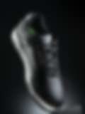 A pair of black sneakers with white soles on a black box against a black background