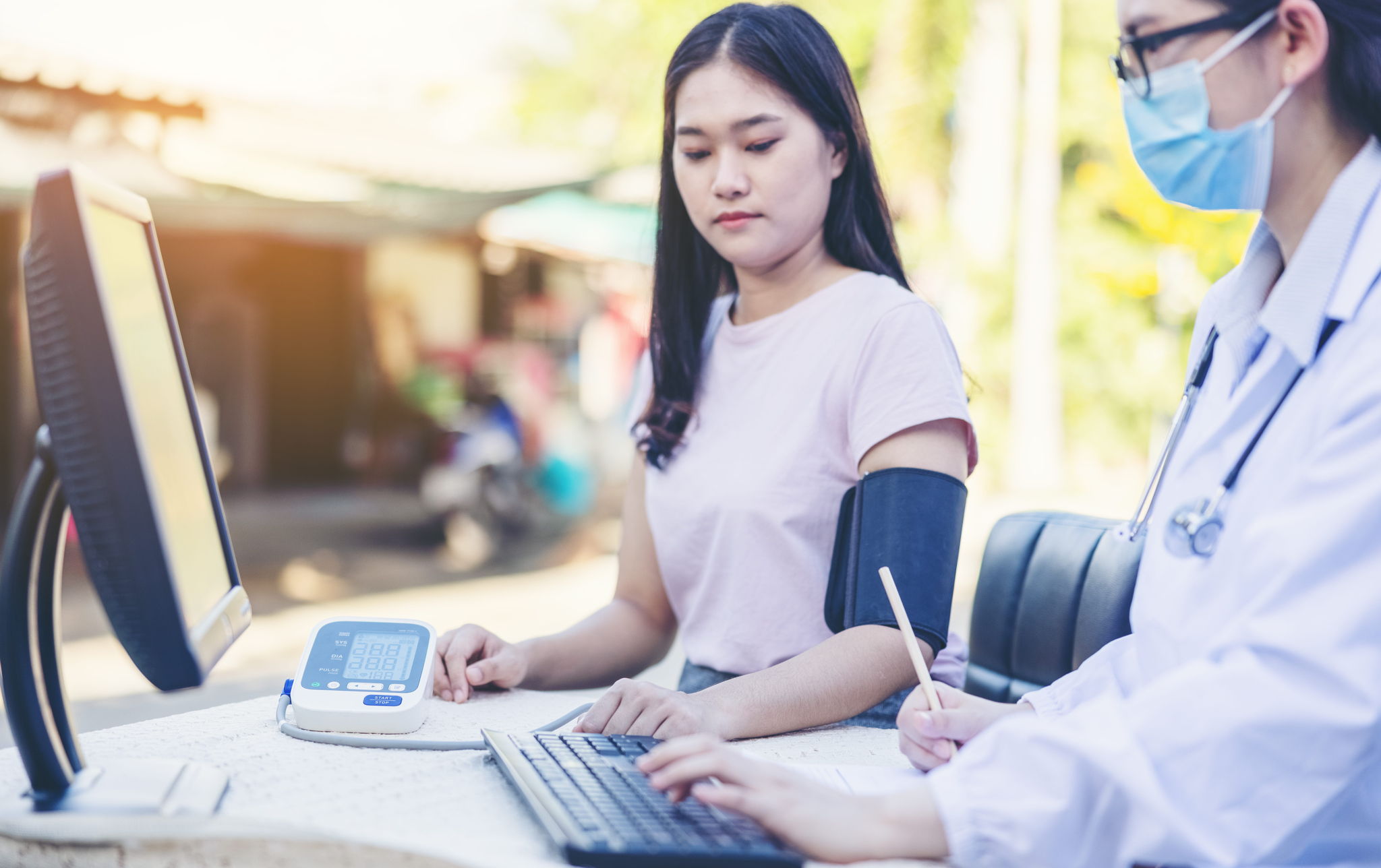 Female Doctor Measuring Blood Pressure Of women patient social service in local village Thailand.