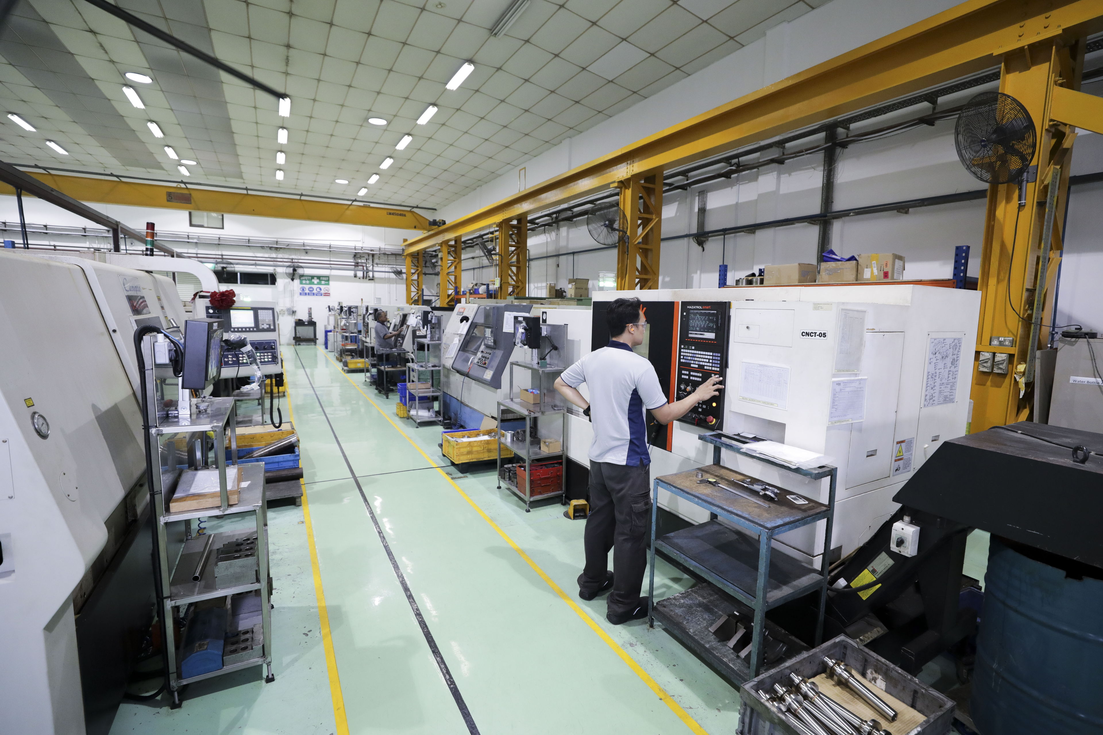View of factory floor showcasing CNC machines and machinists at work