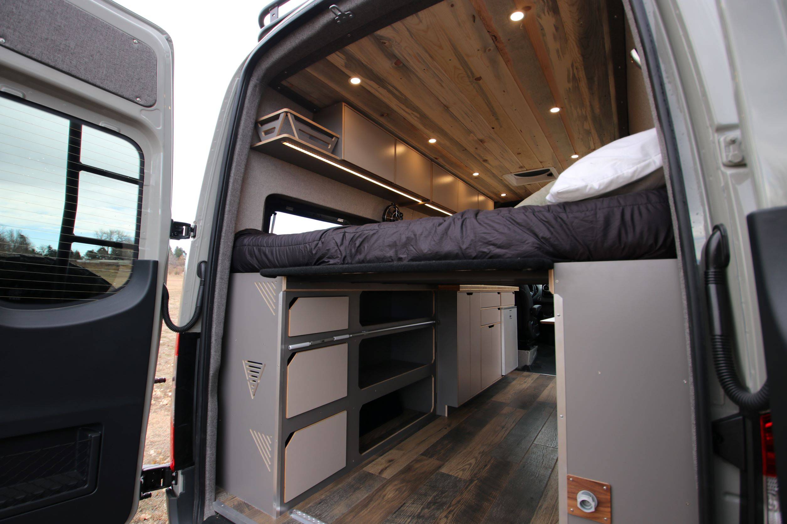 Rack & Roll - Sprinter 144 Conversion Van - Man in Under-Bed Storage Area with Shelves - The Vansmith