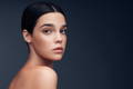 woman looking at her skincare on the dark blue background