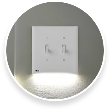 Double gang lighted switch cover on a grey wall 