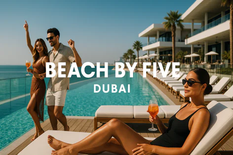 Three people enjoying a sunny day at a luxurious beachfront resort pool in Dubai. A couple stands near the infinity pool with drinks, while a woman relaxes on a sun lounger in the foreground.