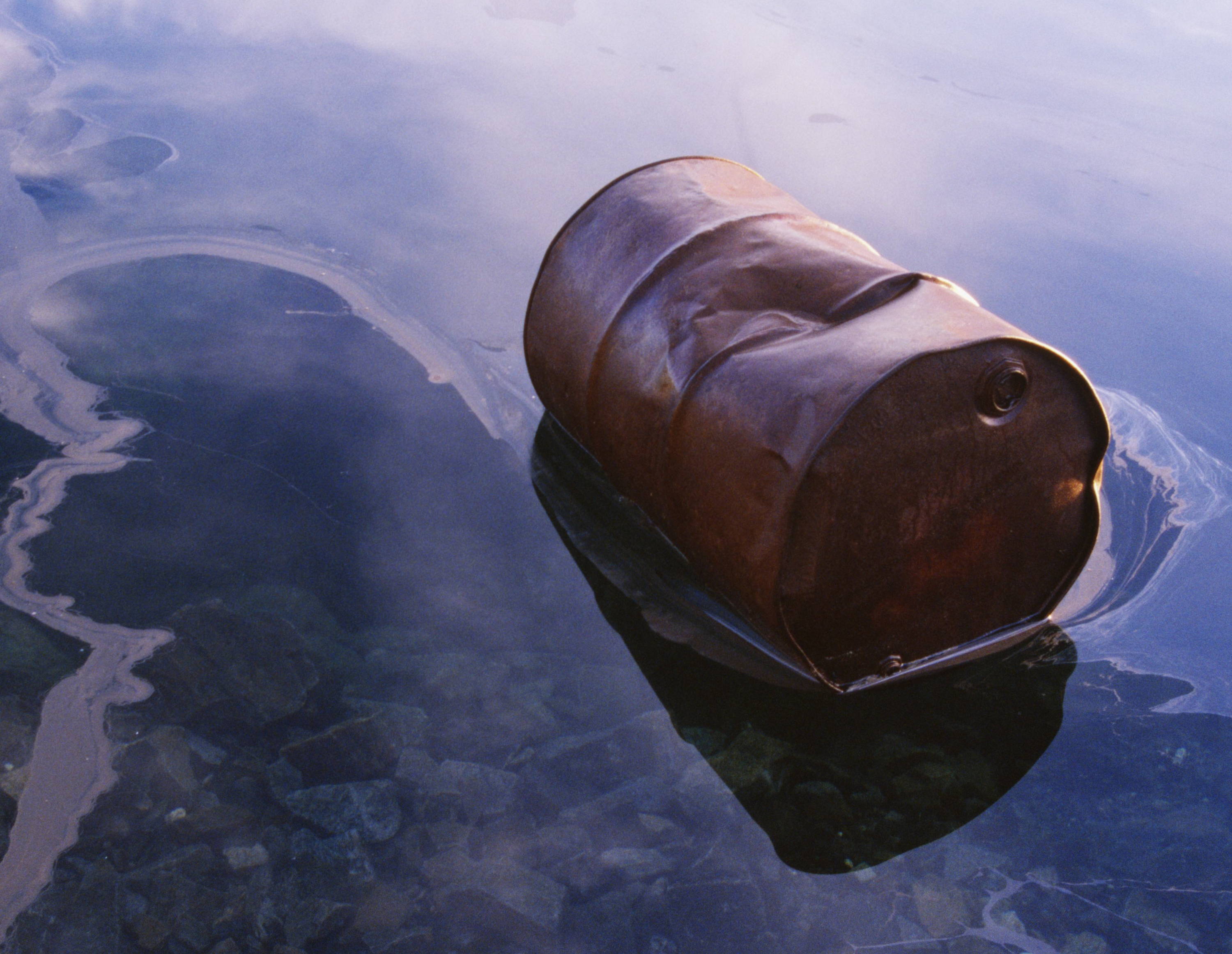 A barrel floating in polluted water