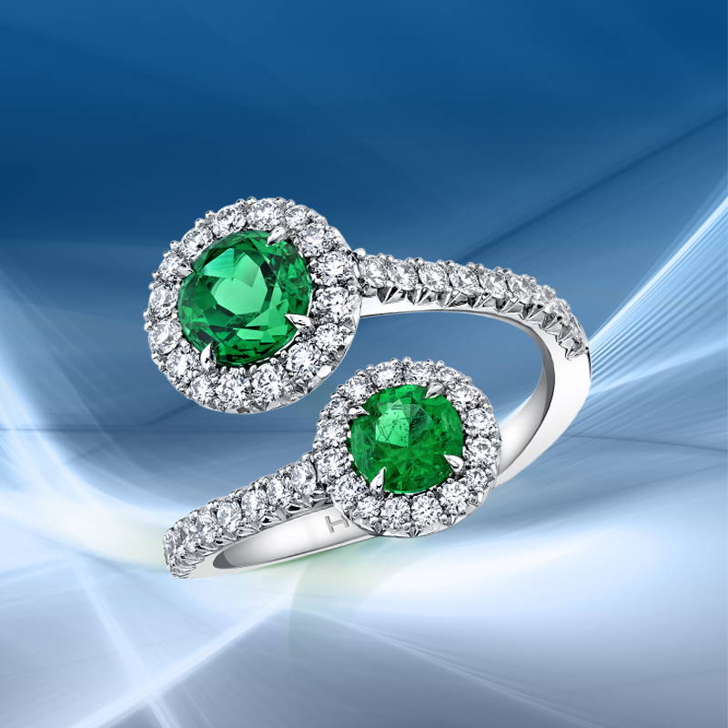 Embrace wrap around ring featuring emeralds and diamonds