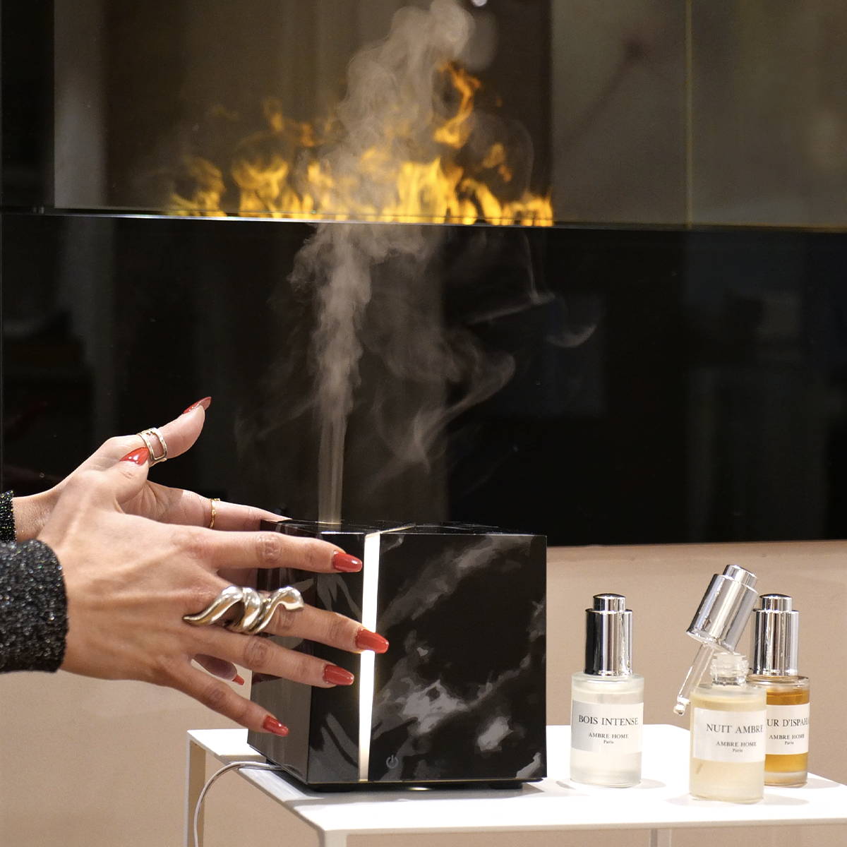 femme locataire le diffuseur marbre noir diffusant du parfum face à une cheminée