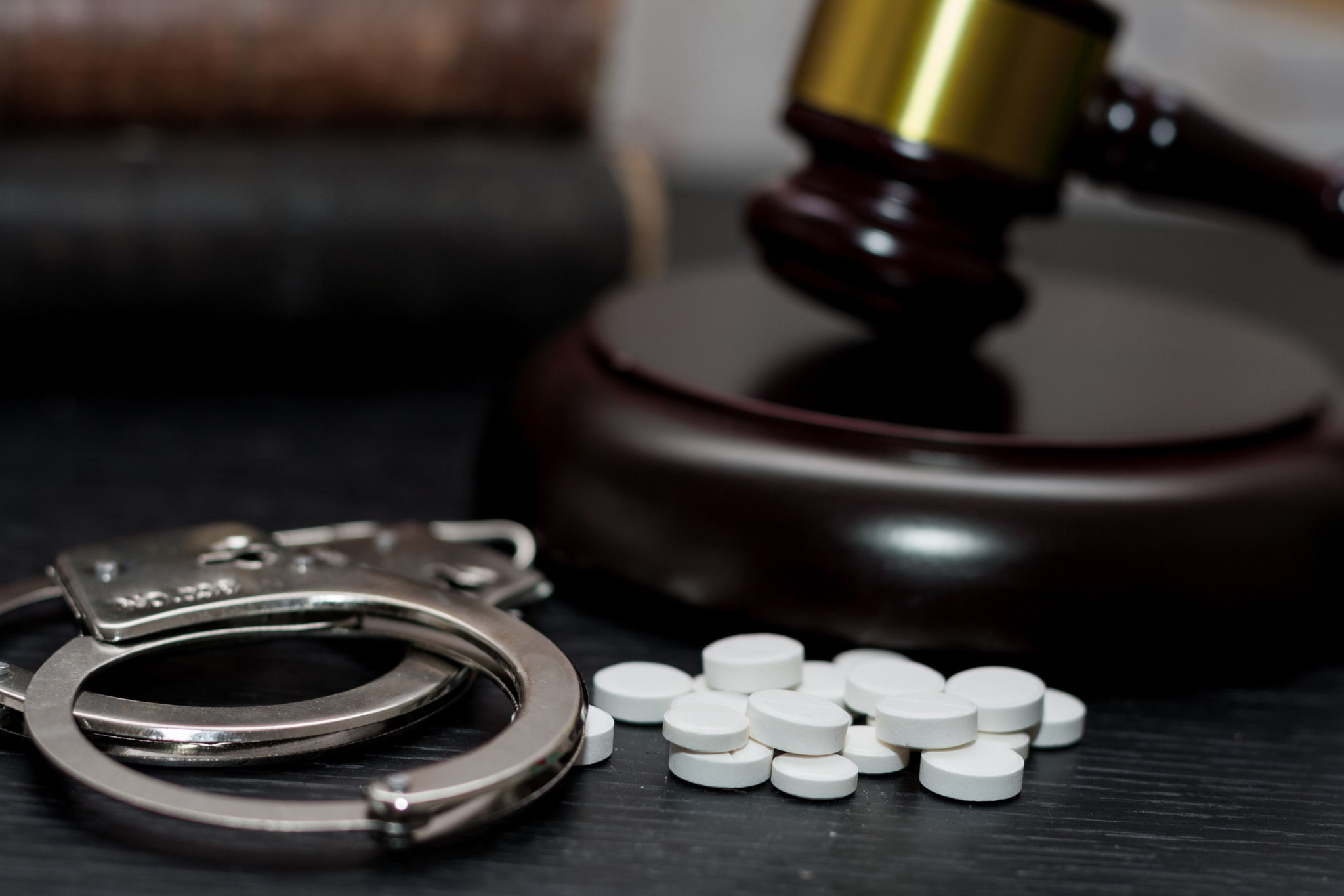 handcuffs pills and a gavel
