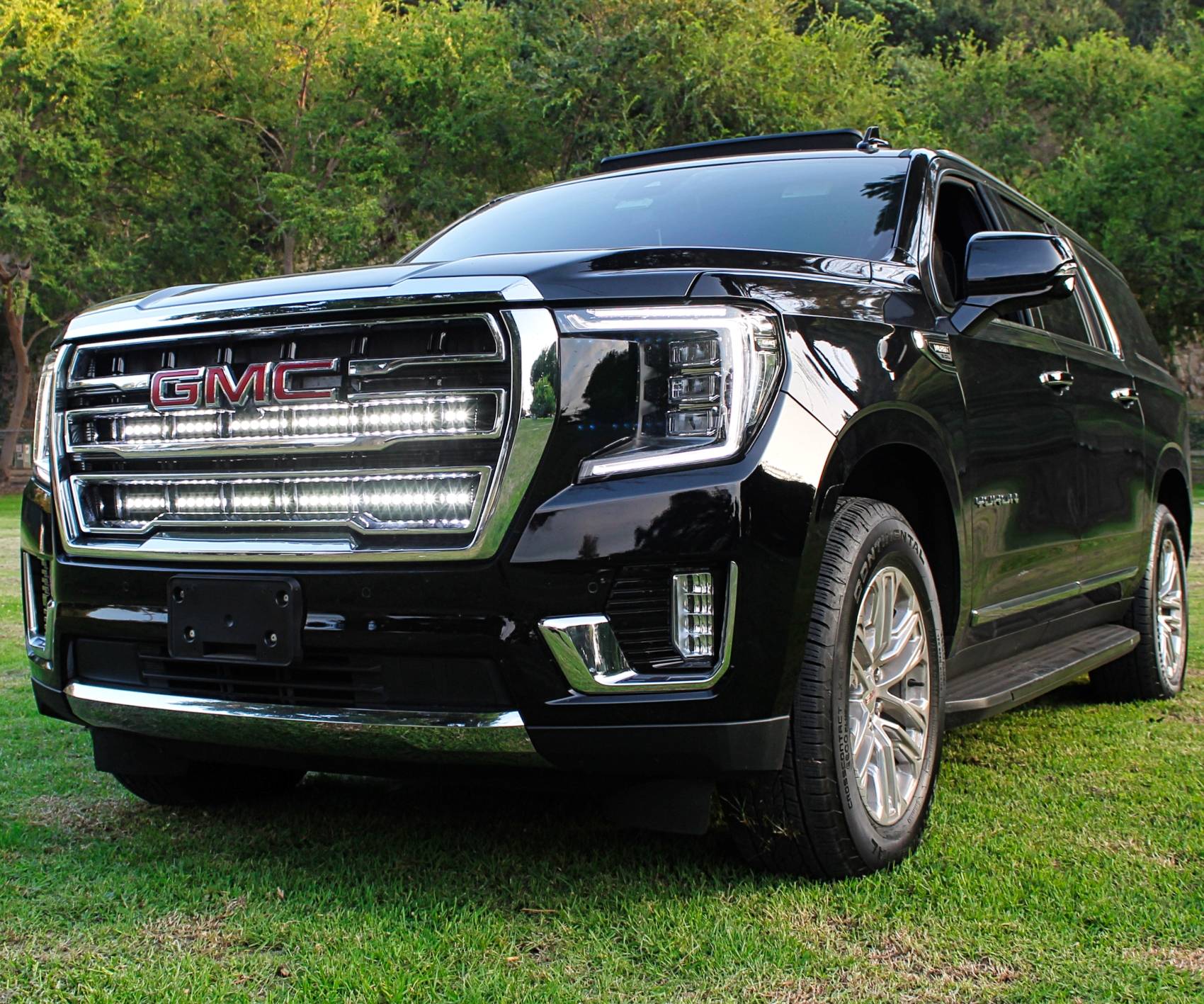 2021 2022 2023 2024 black gmc yukon with two 40in white light bars behind the grille  by mandr automotive